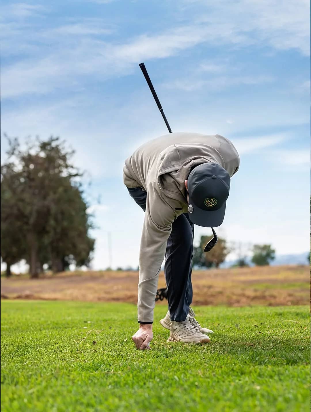 Un golfista clava su bola en el tee sobre el pasto de Nueve Almas Golf